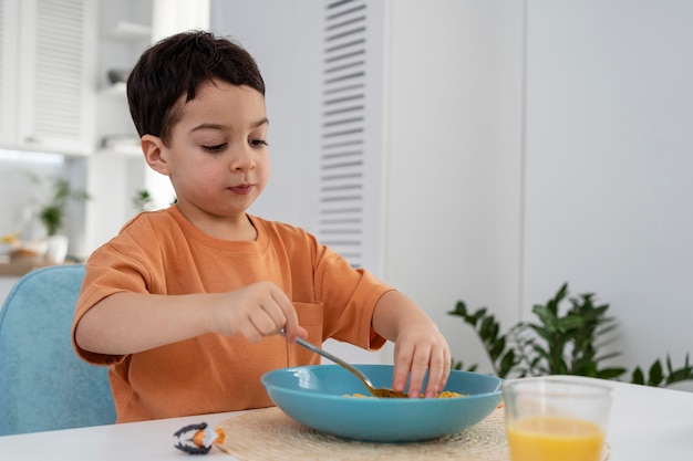 Porträt des niedlichen kleinen Jungen, der Frühstück hat