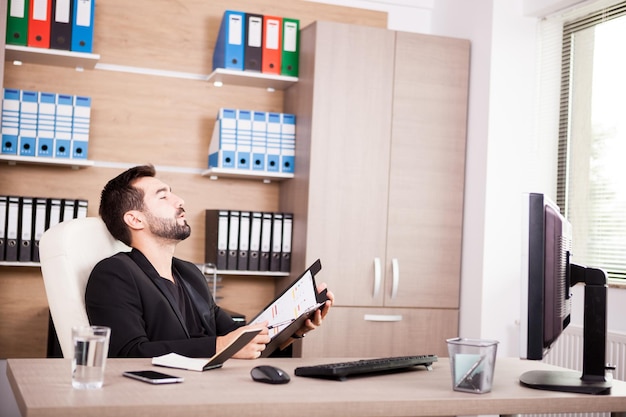 Porträt des professionellen Geschäftsmannes, der in seinem Büro arbeitet. Kaufmann im beruflichen Umfeld