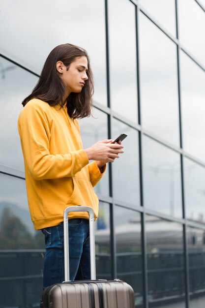 Porträt des Reisenden sein Telefon überprüfend