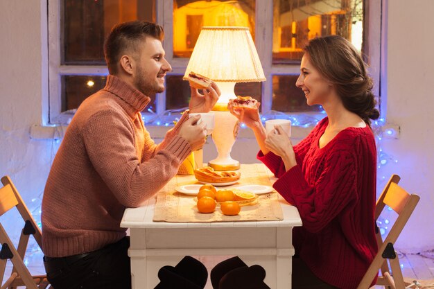 Porträt des romantischen Paares am Valentinstagessen mit Kerzen