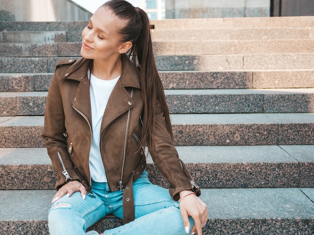 Porträt des schönen Brunettemodells kleidete in der Sommerhippie-Jacke und in der Jeanskleidung an