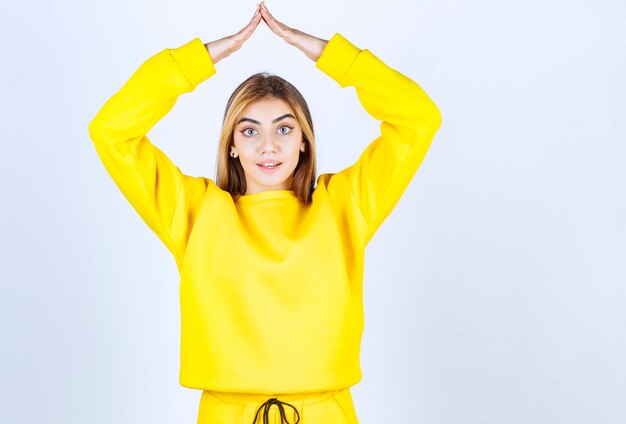 Porträt des schönen Frauenmodells, das im gelben T-Shirt steht und posiert