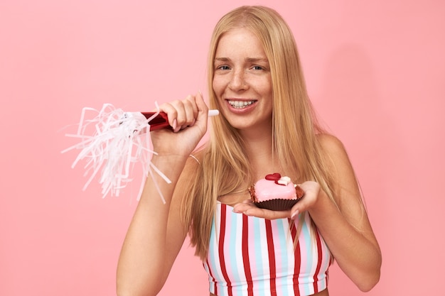 Porträt des schönen hübschen Teenager-Mädchens mit Sommersprossen und Zahnspangen auf ihren Zähnen, die Geburtstagsfeier genießen