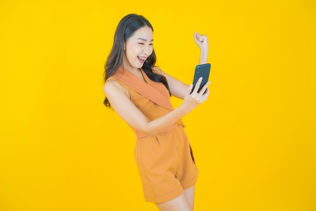 Porträt des schönen jungen asiatischen Frauenlächelns mit intelligentem Handy