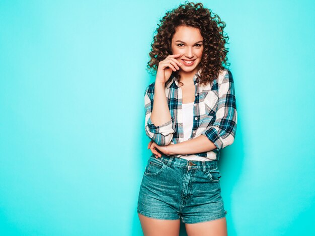 Porträt des schönen lächelnden Modells mit Afro-Lockenfrisur gekleidet in Sommer-Hipster-Kleidung. Trendige lustige und positive Frau