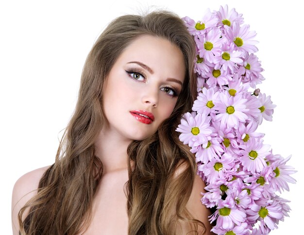 Porträt des schönen Mädchens mit schönen langen Haaren und Frühlingsblumen - weißer Raum