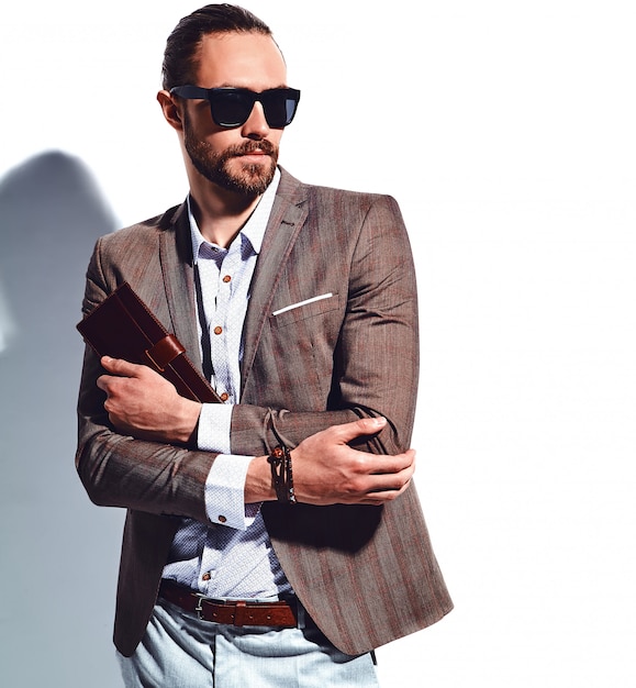 Porträt des schönen modischen Hipster-Geschäftsmannmodells der Mode, gekleidet in eleganten braunen Anzug in Sonnenbrille