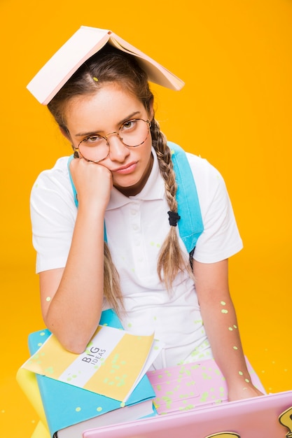 Porträt des Schulmädchens auf gelbem Hintergrund