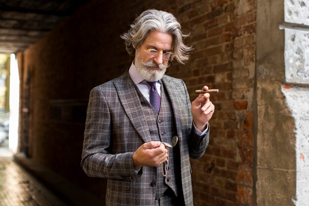 Porträt des selbstbewussten Mannes, der Zigarre hält