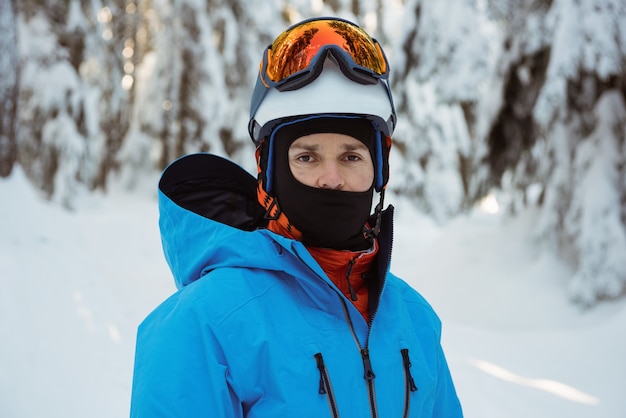 Porträt des Skifahrers, der auf Schneelandschaft steht