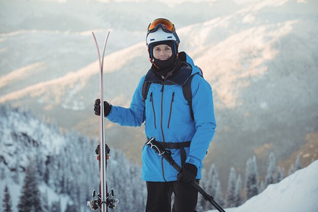 Porträt des Skifahrers, der mit Ski steht