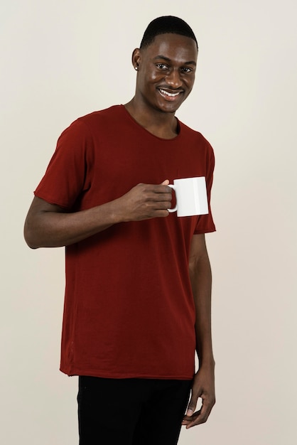 Porträt des Smiley-Mannes in einem T-Shirt, das Becher hält