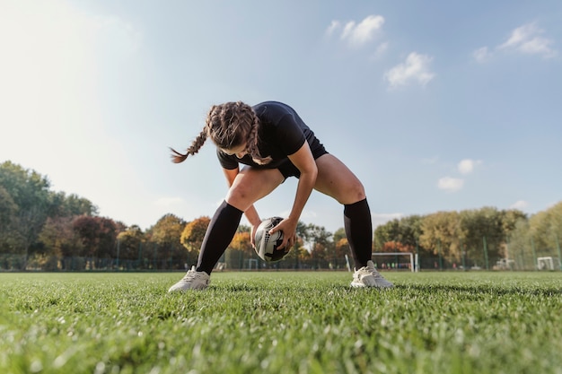 Porträt des sportiven Mädchens spielend mit einem Rugbyball