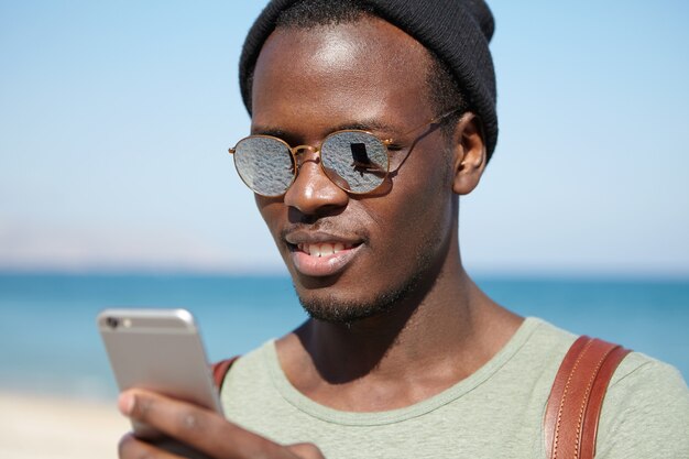 Porträt des stilvollen afroamerikanischen Mannes am Strand