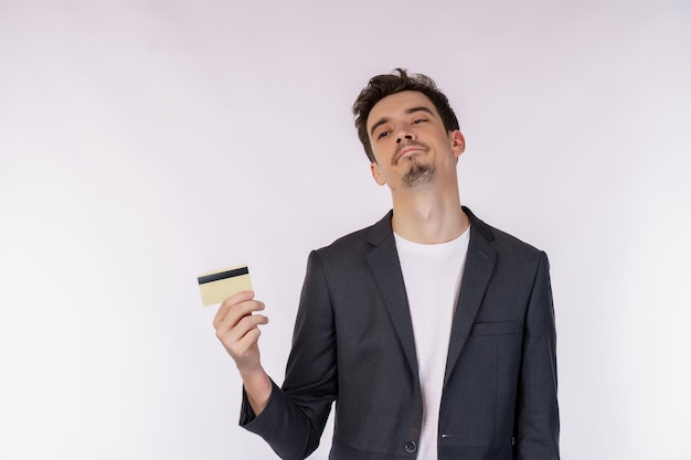 Porträt des unglücklichen Geschäftsmannes, der die Kreditkarte lokalisiert über weißem Hintergrund zeigt