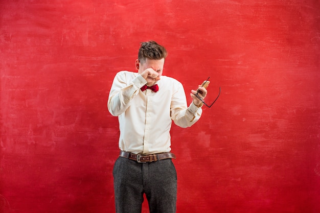 Porträt des verwirrten mannes, der per telefon auf rot spricht
