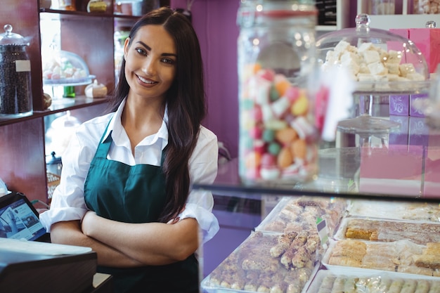 Porträt des weiblichen Ladenbesitzers, der am türkischen Süßigkeitenzähler steht