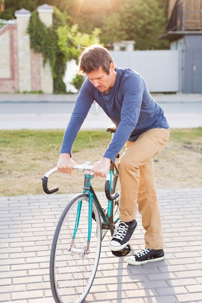 Porträt des zufälligen Mannes, der Fahrrad draußen reitet