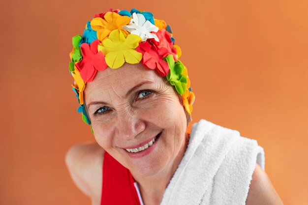 Porträt einer älteren Frau mit geblümter Badekappe und Handtuch