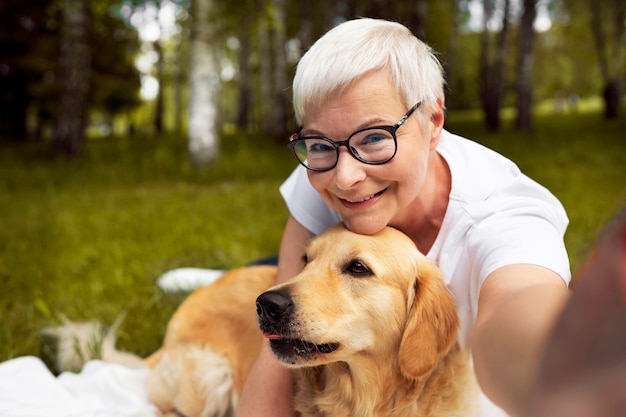 Porträt einer älteren Person, die mit ihrem Hund ein Selfie macht