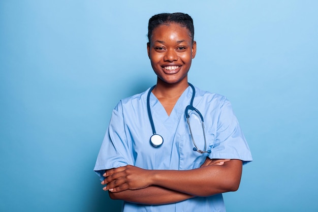 Porträt einer afroamerikanischen praktizierenden Krankenschwester, die in die Kamera lächelt und an der Krankheitsexpertise arbeitet