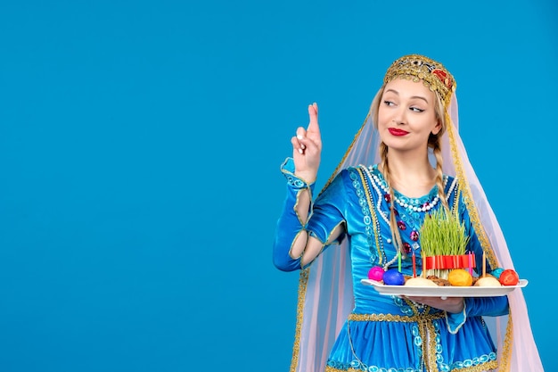 Porträt einer aserbaidschanischen Frau in traditioneller Kleidung mit ethnischer Geldtänzerin des blauen Hintergrundes Novruz Xonca