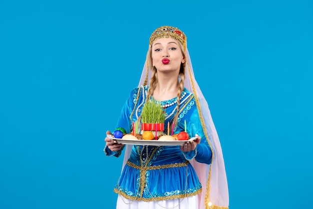 Porträt einer aserbaidschanischen Frau in traditioneller Kleidung mit Novruz Xonca Studio schoss blauen Hintergrund ethnischen Konzept Frühling