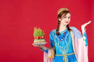 Kostenloses Foto porträt einer aserbaidschanischen frau in traditioneller kleidung mit sperma auf rot