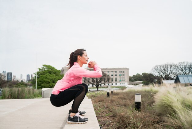 Porträt einer athletischen Frau, die Übung am Park im Freien tut. Sport und gesunder Lebensstil Konzept.