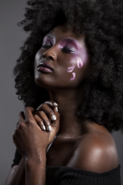 Kostenloses Foto porträt einer attraktiven afroamerikanischen frau mit schönem make-up, das mit geschlossenen augen aufwirft