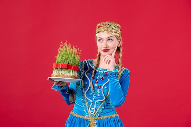 Porträt einer azerinischen Frau in traditioneller Kleidung mit Semeni Studio schoss rotem Hintergrund Novruz Tänzerin Frühlingskonzept Foto