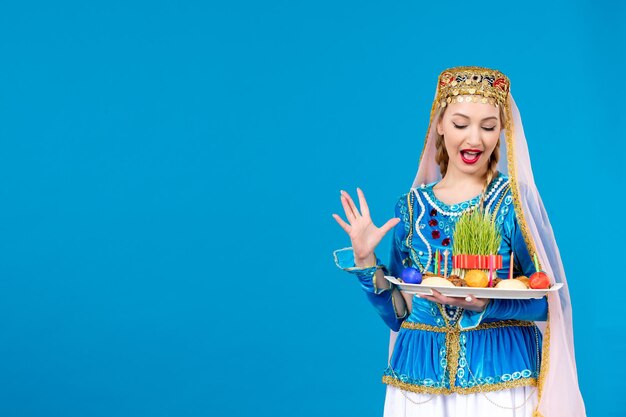 Porträt einer azerinischen Frau in traditioneller Kleidung mit Xonca auf blauem Hintergrund Novruz-Konzept ethnische Tänzerin