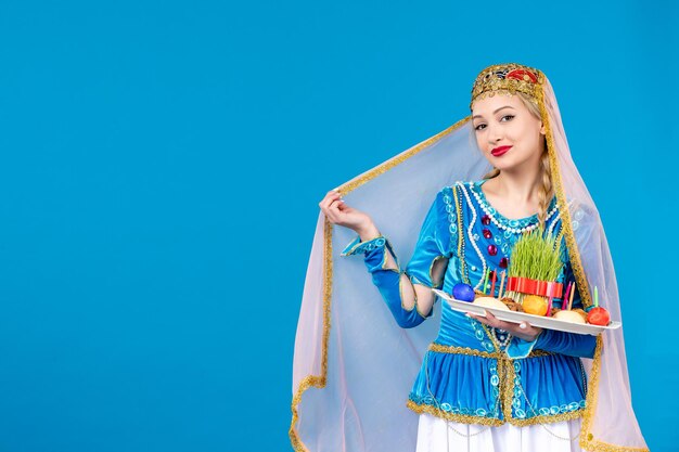 Porträt einer azerinischen Frau in traditioneller Kleidung mit Xonca Studio schoss blauem Hintergrund Frühlingskonzept Novruz Tänzer ethnischen Farben