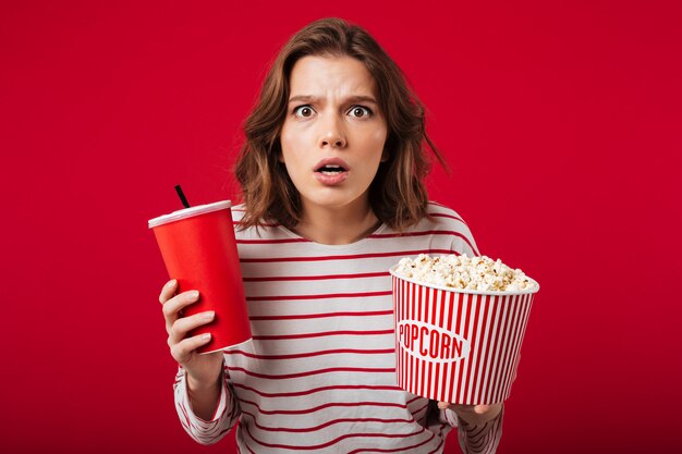 Porträt einer entsetzten Frau, die Popcorn hält