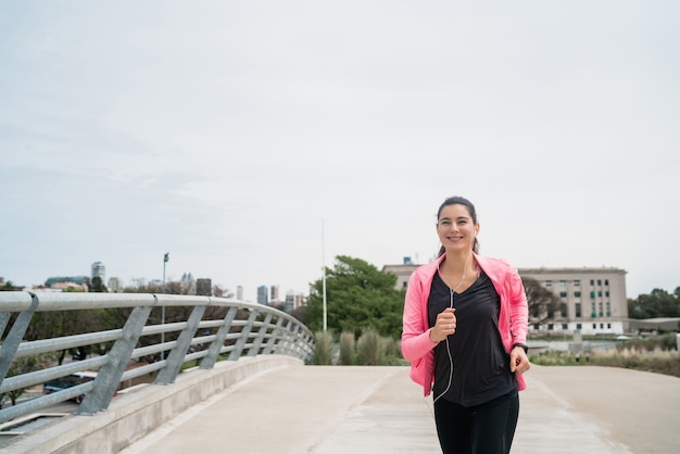 Kostenloses Foto porträt einer fitnessfrau, die draußen in der straße läuft. sport und gesunder lebensstil konzept.