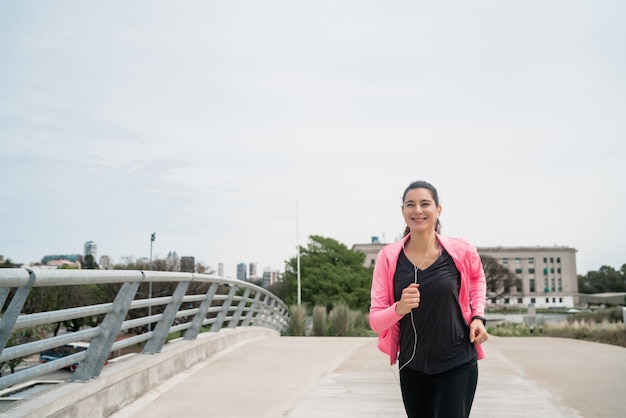 Porträt einer Fitnessfrau, die draußen in der Straße läuft. Sport und gesunder Lebensstil Konzept.