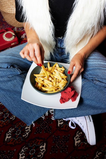 Kostenloses Foto porträt einer frau, die ein gericht mit poutine genießt