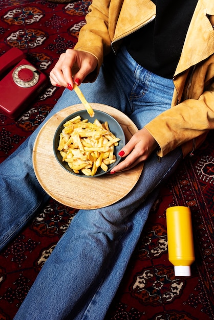 Porträt einer Frau, die ein Gericht mit Poutine genießt