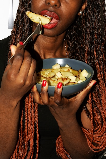 Porträt einer Frau, die ein Gericht mit Poutine isst