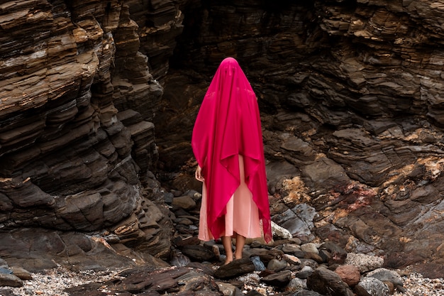 Porträt einer Frau, die ihr Gesicht mit Schleier am Strand bedeckt