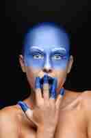 Kostenloses Foto porträt einer frau, die mit blauer farbe bedeckt posiert