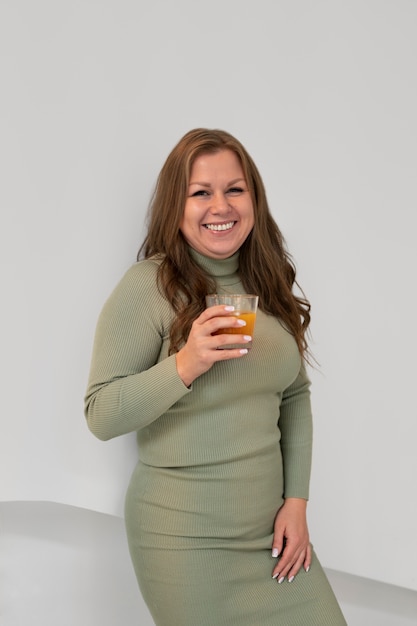Porträt einer Frau in Übergröße, die einen Drink in einem Restaurant genießt