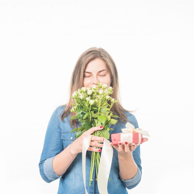 Porträt einer Frau mit riechenden Blumen der Geschenkbox auf weißem Hintergrund