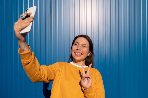 Porträt einer Frau mit Smartphone mit Pop-Socket im Freien