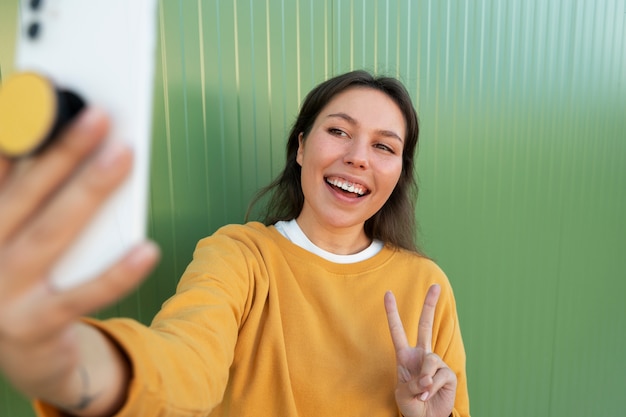 Kostenloses Foto porträt einer frau mit smartphone mit pop-socket im freien