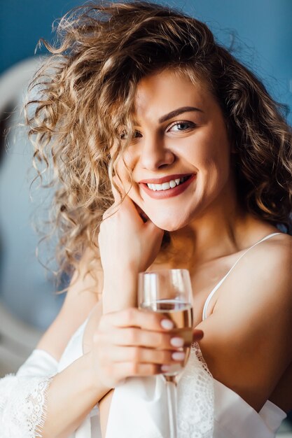 Porträt einer glücklich lächelnden charmanten Frau mit einem Glas Champagner