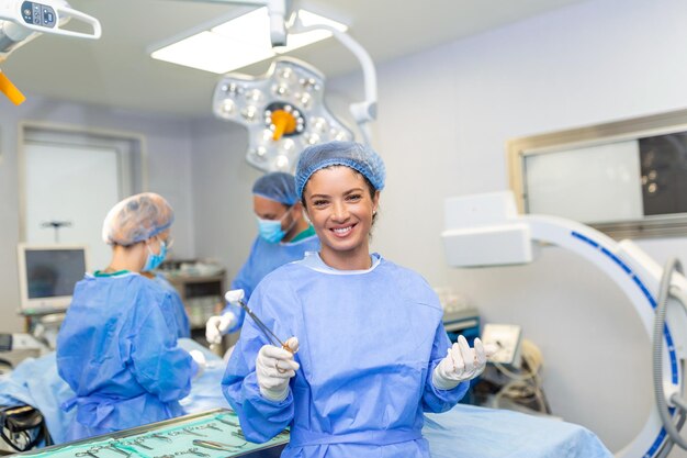 Porträt einer glücklichen Chirurgin, die im Operationssaal steht und bereit ist, an einem Patienten zu arbeiten Weibliche medizinische Arbeiterin in chirurgischer Uniform im Operationssaal