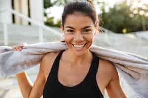 Kostenloses Foto porträt einer glücklichen fitnessfrau mit handtuchruhe