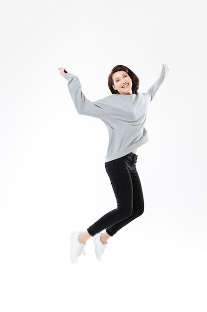 Porträt einer glücklichen fröhlichen Frau, die springt und Erfolg feiert