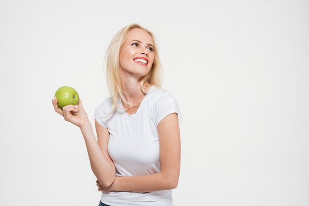 Porträt einer glücklichen hübschen Frau, die grünen Apfel hält